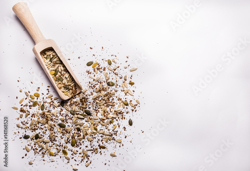 Sesame seeds, pumpkin seeds, sunflower seeds, chia seeds, flax seeds, poppy seeds and a wooden spoon