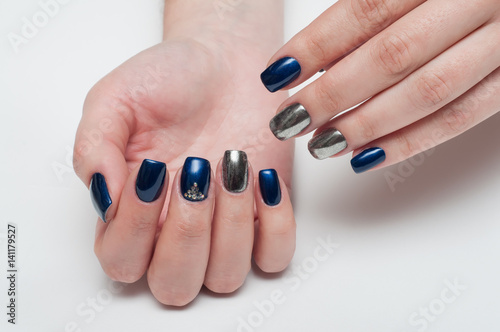 Festive manicure on long square blue nails with melate, mirror and crystals
