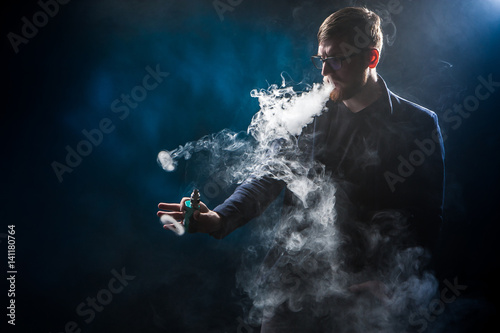 The man releases rings of smoke. Tricks with smoke. © Grispb