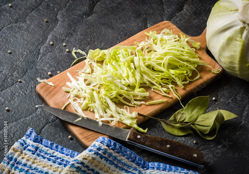 Chopped cabbage on a black stone background.