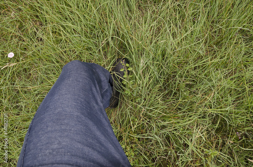 Close up of dirty and wet boots on the green grass