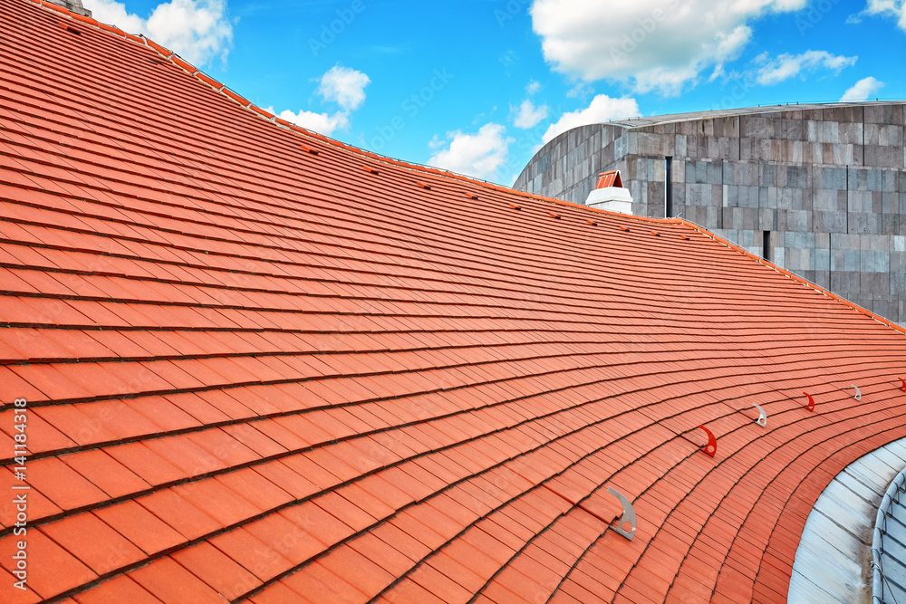 Tile roof with blue sky and clouds in background