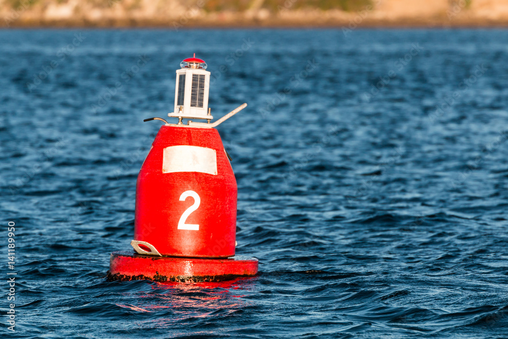 Red (Nun) companion buoy and boating channel marker in harbor. Stock Photo Adobe Stock