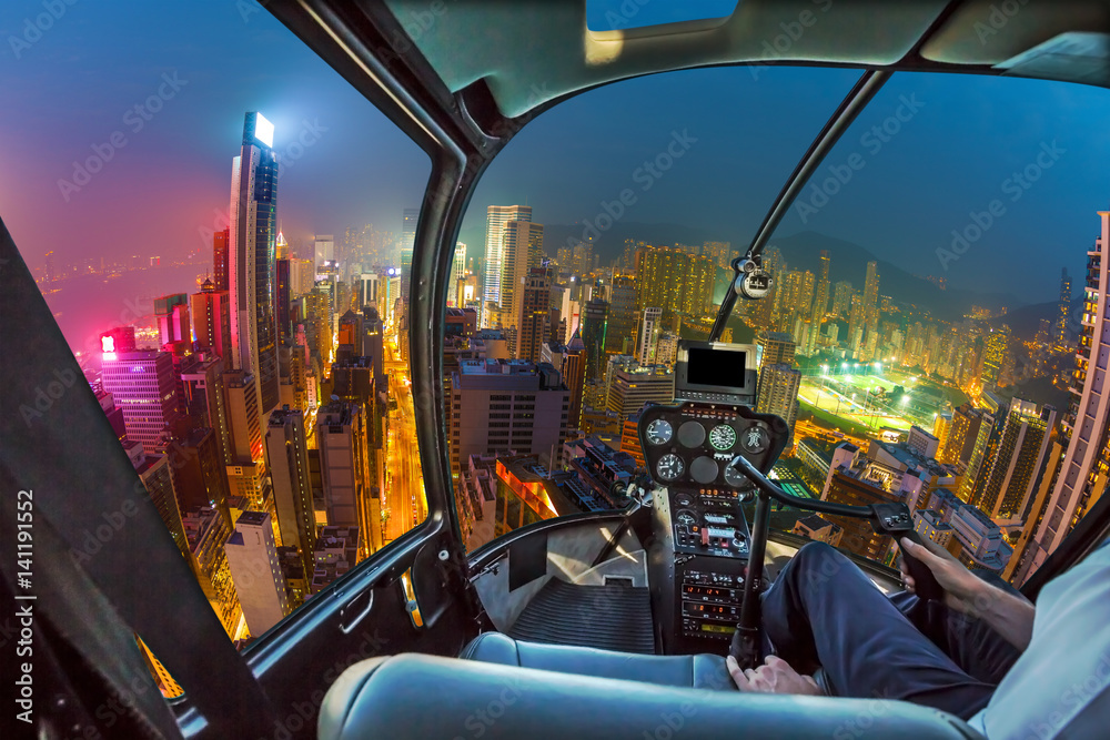 Obraz premium Helicopter cockpit flying on Hong Kong skyscrapers at night in Wan Chai district, Hong Kong island. Fisheye view.