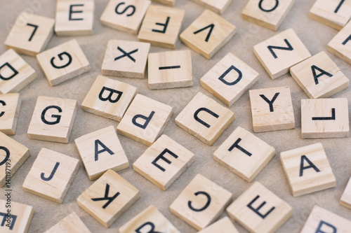 background of letterpress wood type printing blocks, random letters of alphabet and punctuation stained by black inks