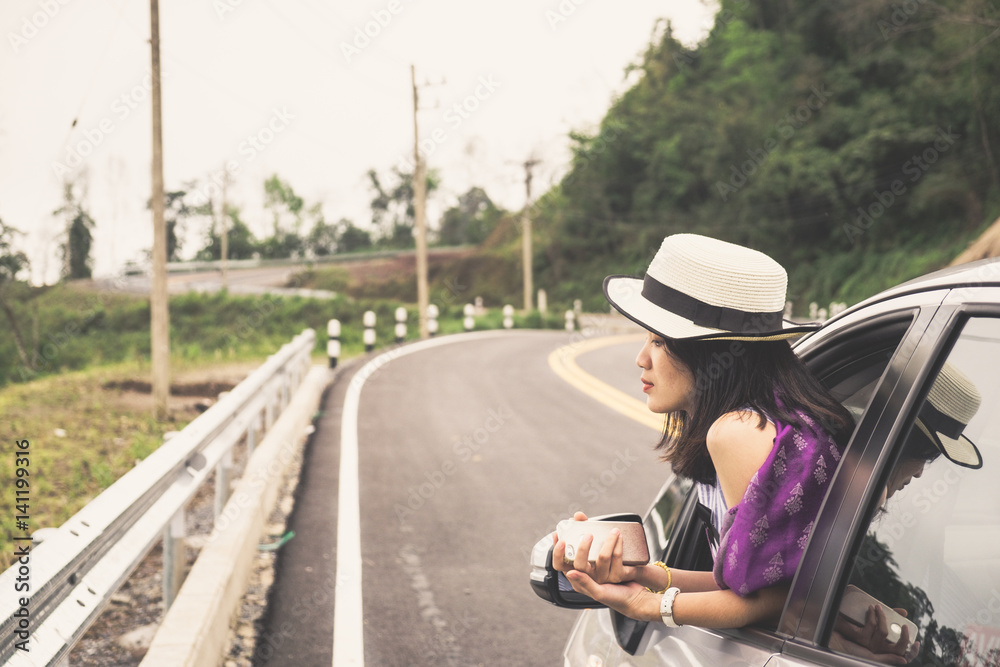 Fototapeta premium Asain woman traveler with hatchback car with beautiful mountain