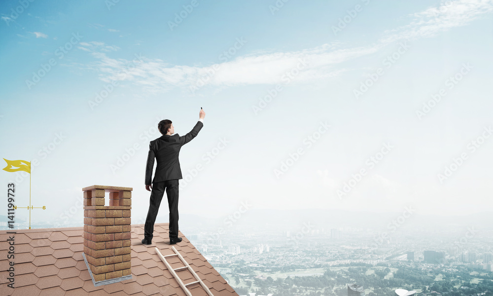 Businessman on house roof touch empty space. Mixed media