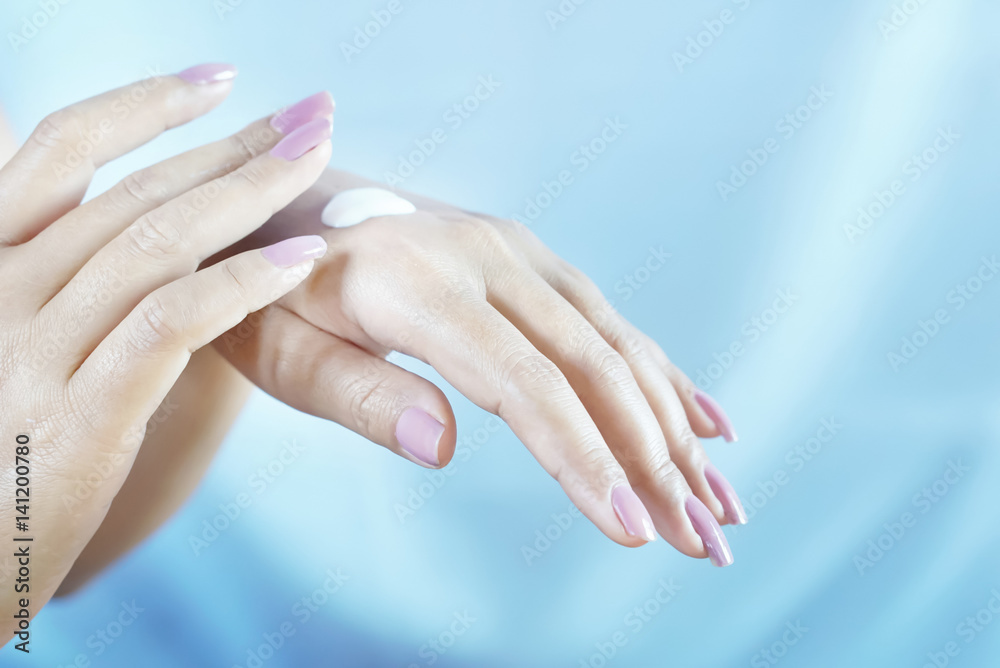 Naklejka premium close-up of woman putting some moisturizing cream on her hand