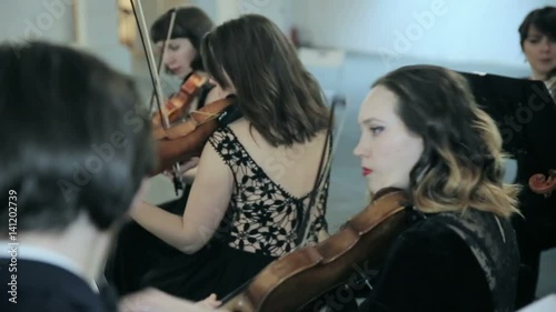 Close-up of musician playing violin on the symphony hall photo