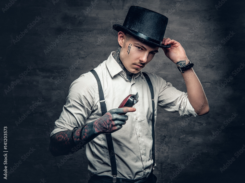 A man with tattoo on a face holds hair trimmer. A man with tattoo on a face holds hair trimmer.
