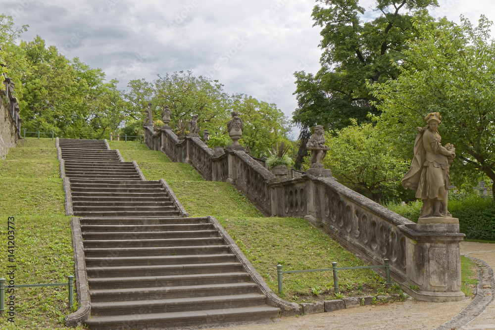 Old stone stairs in an abandoned park with sculptures on the sides