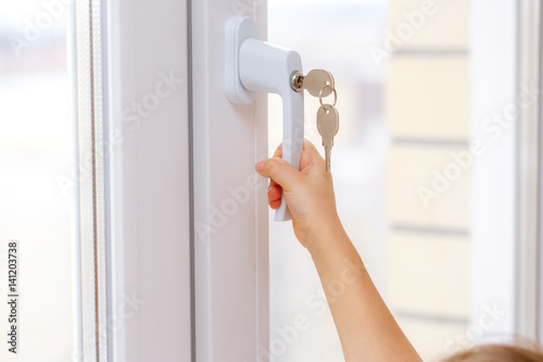 Child's hand on secure window handle