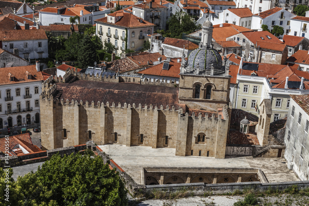 Ancient stone church among the houses in Coimbra, Portugal
