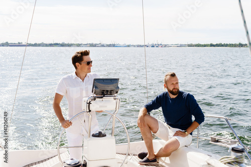 Two happy friends traveling on a yacht. Vacation, tourism, holiday, concept. © Acronym