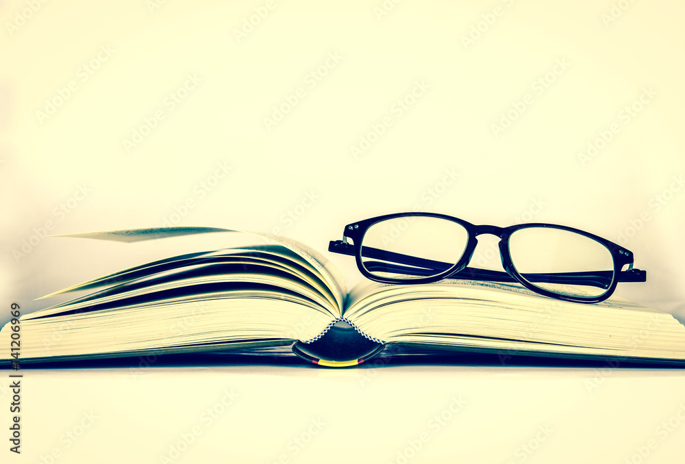 black rimmed glasses placed on opened book black rimmed glasses placed on opened book