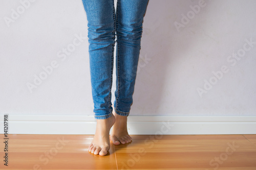 Feet of woman standing on tiptoe with blue jean