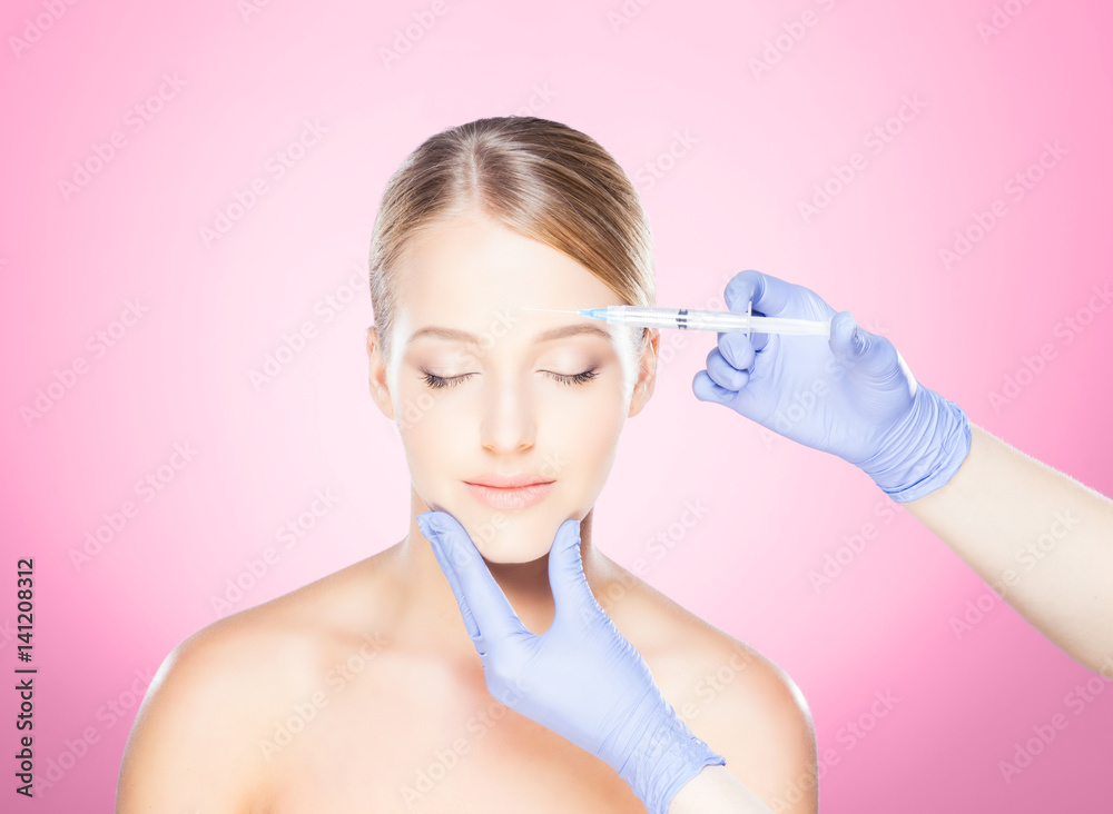 Doctor injecting in a beautiful face of a young woman. Plastic surgery concept. Doctor injecting in a beautiful face of a young woman. Plastic surgery concept.