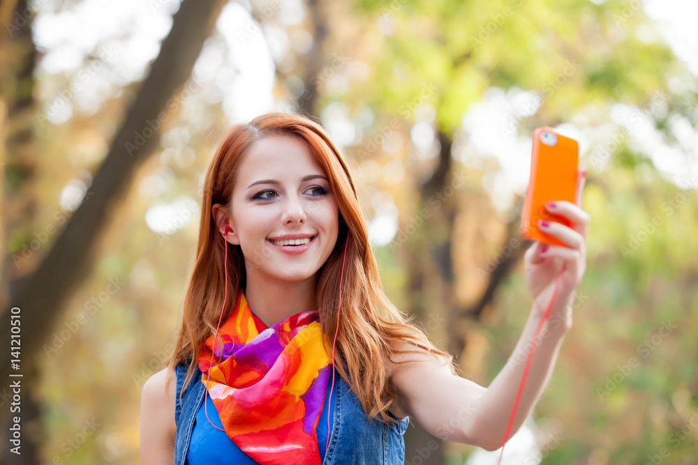 beautiful young woman holding her mobile phone and taking selfie on the ...