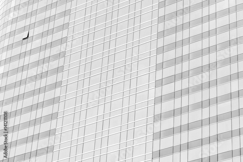 Cloud reflection in high glass offices. Blue reflection of the sky. Windows of a building. Business background in monochrome.