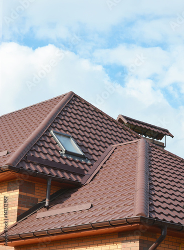 New roofing construction with attic skylights, rain gutter system, roof windows and roof protection from snow. Modern house roofing with attic skylight. Waterproofing roofing construction area.