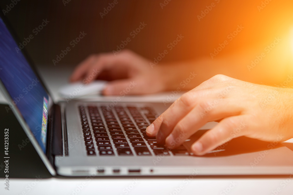Hand typing on a keyboard of laptop with operating system screen on background Hand typing on a keyboard of laptop with operating system screen on background