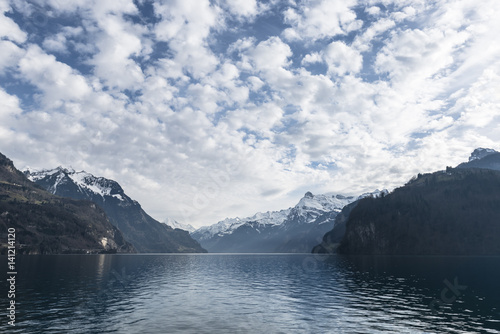 Cold winter day on a mountain lake. Mountainous landscape. Swiss Alps. Cloudy sky above Lake Lucerne.