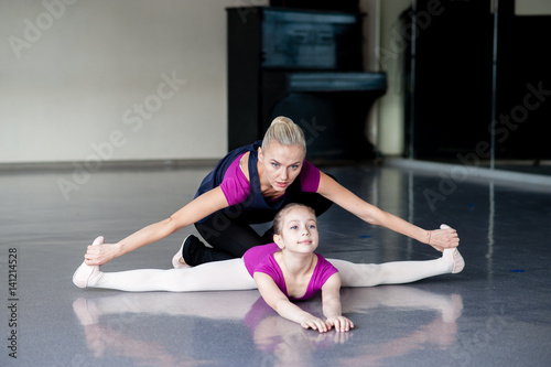 Healthy life education by example - woman and little girl exercising together