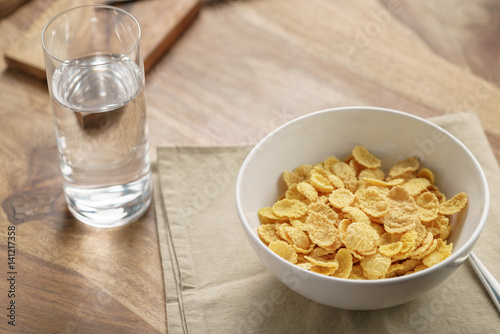 dry corn flakes for breakfast in bowl on table, breakfast preparation