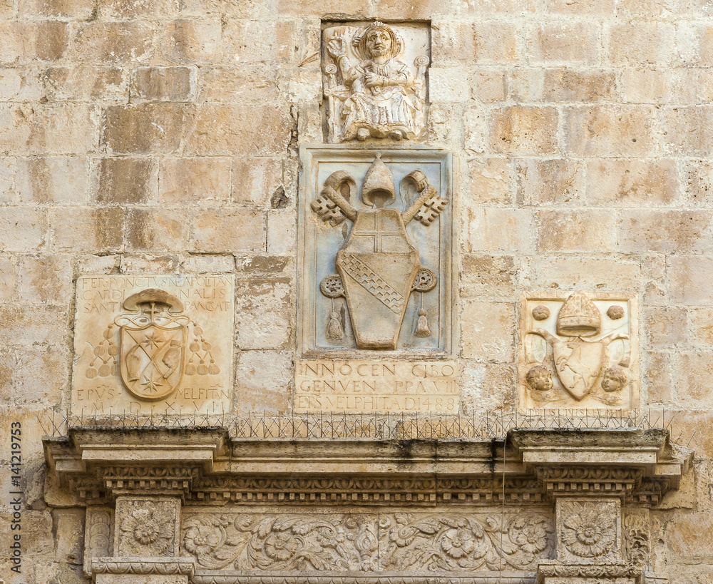 bas-reliefs of stone with Latin inscription surmounting the entrance of the cathedral bisceglie, Puglia. Italy