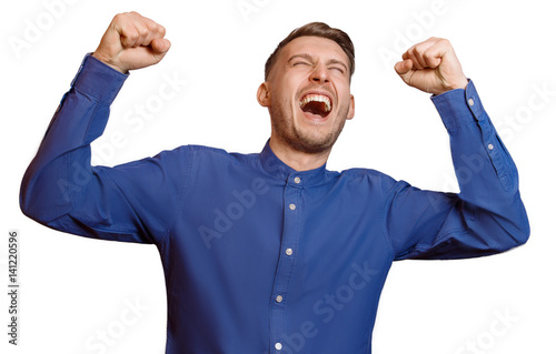Young guy screams with his fists raised, isolated photo