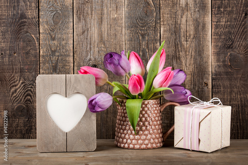 Gift box, colorful tulips and heart shaped frame
