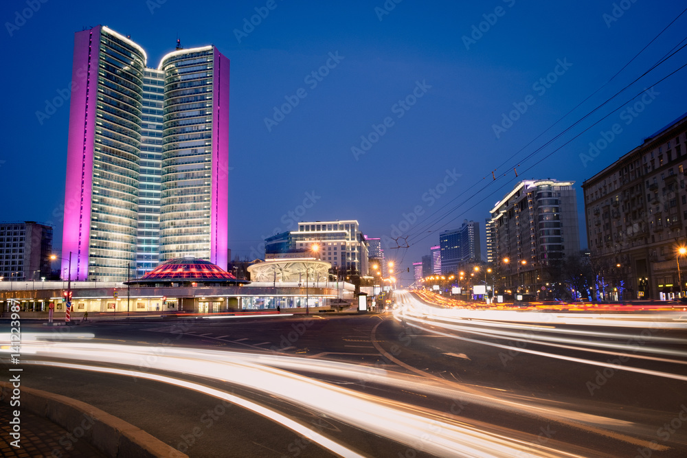 Blurred night traffic movement at the city center of Moscow, urban view with skyscraper and city illumination lights, outdoor travel background