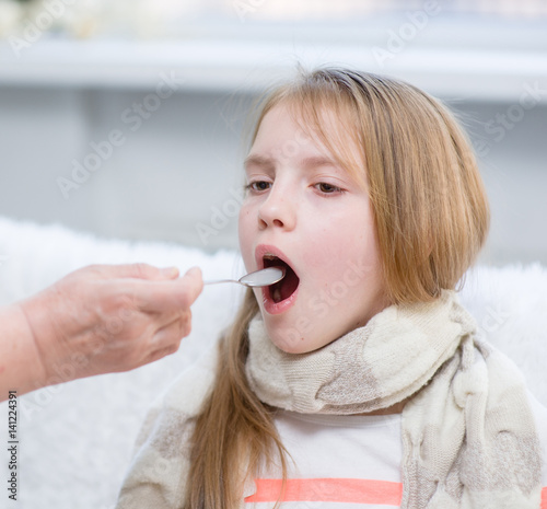 girl taking medicine with spoon