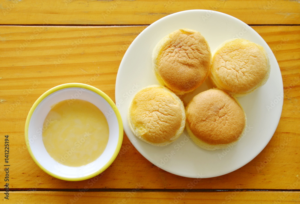 fresh butter cupcake on dish dipping with sweet vanilla sauce fresh butter cupcake on dish dipping with sweet vanilla sauce