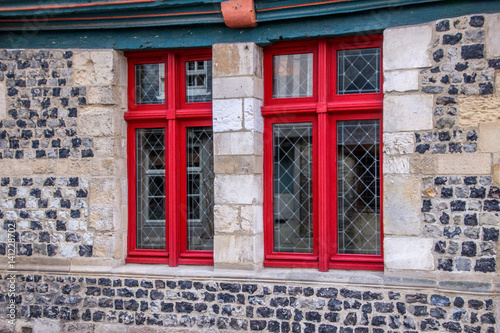 Fototapeta Naklejka Na Ścianę i Meble -  Alte Hausfassade mit Fenstern und Türe, Rote Fensterrahmen aus Holz