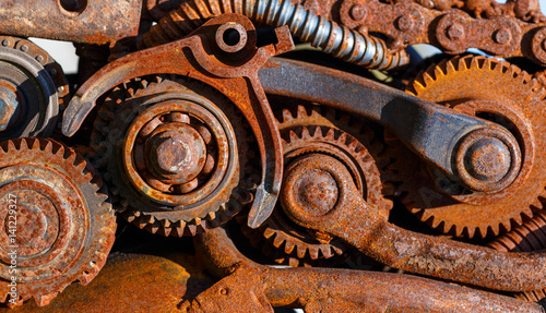 Part of the old mechanism with metal gears, sprockets, chain and other parts covered with rust. photo