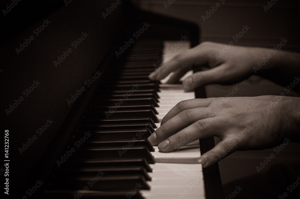 Fototapeta premium Hand over a piano keyboard