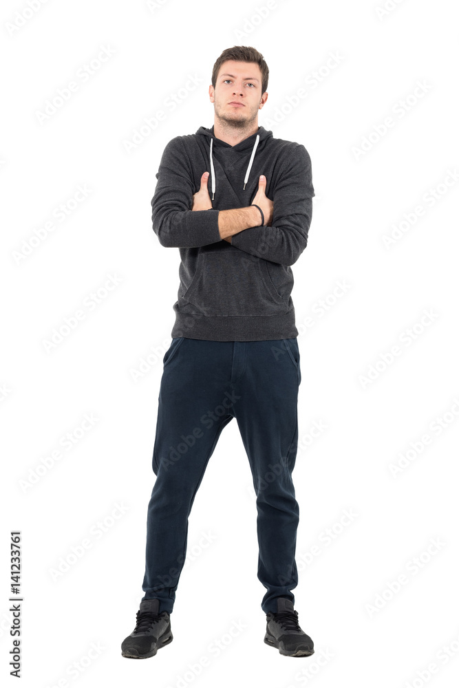 Proud young cool man in comfortable sportive clothing with crossed hands. Full body length portrait over white studio background. Proud young cool man in comfortable sportive clothing with crossed hands. Full body length portrait over white studio background.