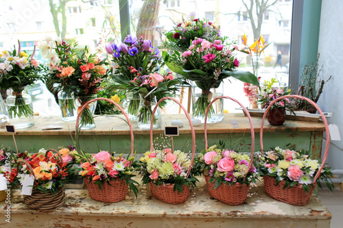 Bukiety z kolorowych kwiatów w koszach w kwiaciarni.