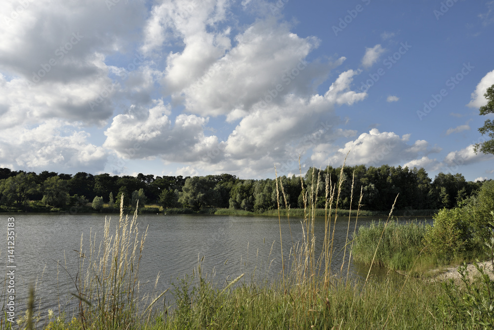 See bei Sonnenschein und blauem Himmel mit weissen Wolken See bei Sonnenschein und blauem Himmel mit weissen Wolken