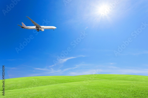 Green grass field with airplane  blue sky and cloud background.