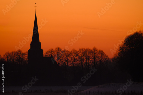 Silhouette of church against a sunset