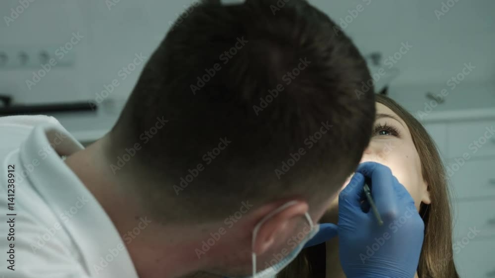 Dentist beginning the check up of his patient at the dentist cabinet Dentist beginning the check up of his patient at the dentist cabinet