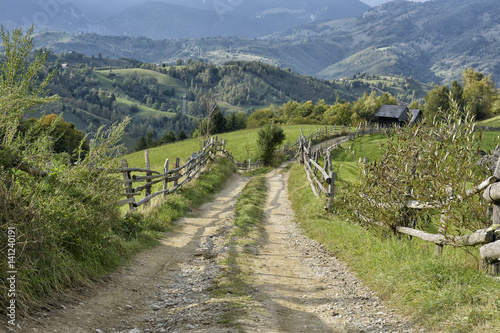 September rural scene in Carpathian mountains. Authentic village and fence