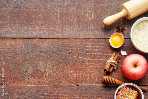 Making apple pie background. Apple, whole grain flour, honey, egg, cinnamon, roller pin on a wooden rustic table. Copy space. photo