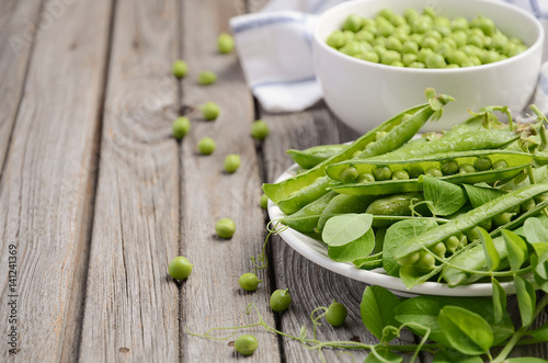 Fresh green peas on rustic wooden background, selective focus. copy space
