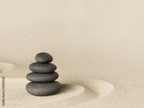 Balance and harmony  zen stone garden background. Dark black stones on fine sand standing for concentration and relaxation..