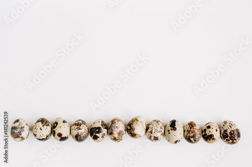 Quail eggs on white background. Flat lay, top view. Easter concept. © Floral Deco