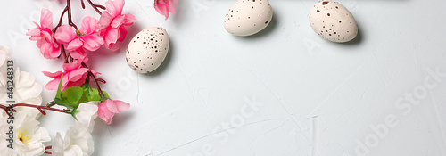 Painted easter eggs and branches of spring sakura closeup on a light blue background with space for congratulation, border design panoramic banner