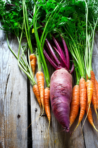 Fresh organic beetroot and carrots on a wooden background